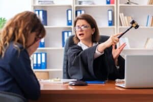 Ein Richter im Gerichtssaal hält einen hölzernen Richterhammer und signalisiert mit einer abweisenden Handbewegung eine Ablehnung