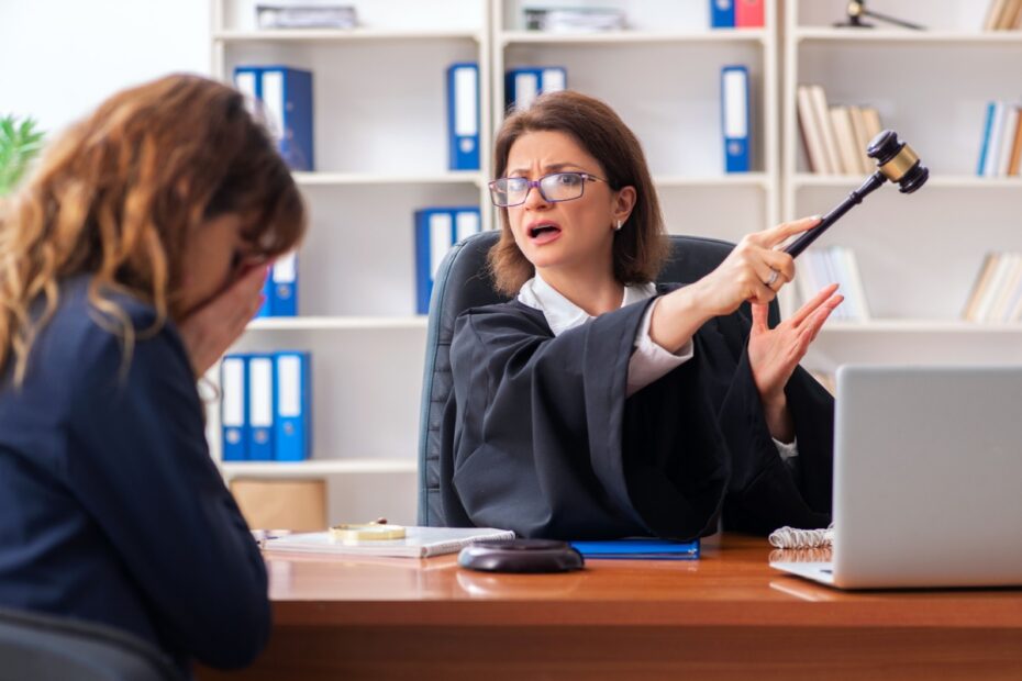 Ein Richter im Gerichtssaal hält einen hölzernen Richterhammer und signalisiert mit einer abweisenden Handbewegung eine Ablehnung