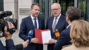 Zwei Landespolitiker sprechen vor dem Bundesbauministerium mit Journalisten über die Wohngeld-Kürzung