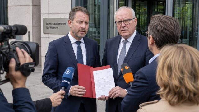 Zwei Landespolitiker sprechen vor dem Bundesbauministerium mit Journalisten über die Wohngeld-Kürzung