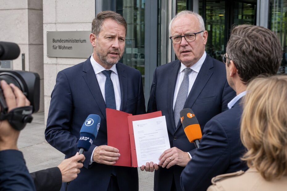 Zwei Landespolitiker sprechen vor dem Bundesbauministerium mit Journalisten über die Wohngeld-Kürzung